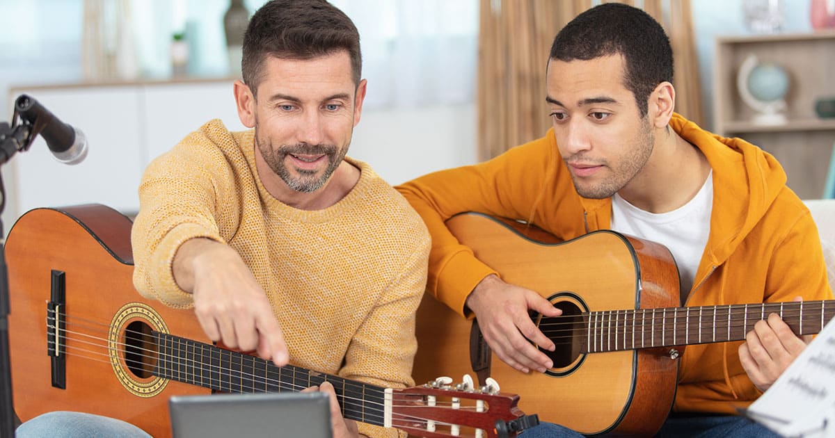 two men playing guitar at sober living in long island